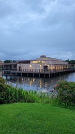 Building by river against cloudy sky
