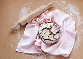 Directly above shot of cookie by rolling pin on table