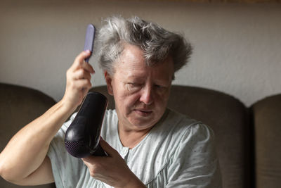 Portrait of young woman using mobile phone at home