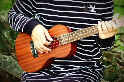 Close-up of man playing guitar