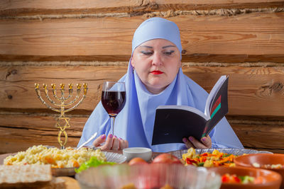 Portrait of young woman having food on table