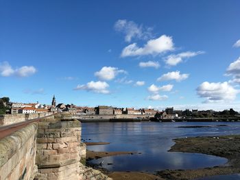 City at waterfront against blue sky