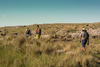 People playing on field against clear sky