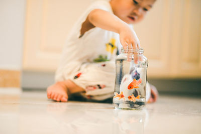 Girl playing with glass on table