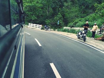 People riding motorcycle on road