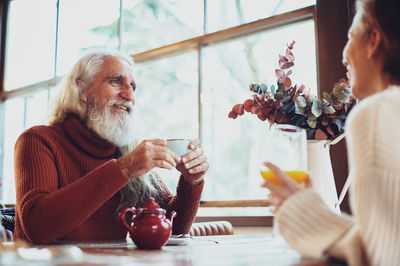 Rear view of man and woman sitting at table