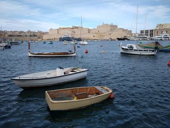 Boats moored in sea against city