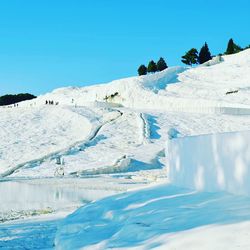 Scenic view of snow covered mountains against clear blue sky