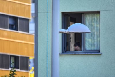 Rear view of man on window of building