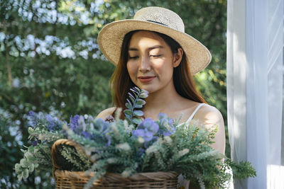 Close-up of beautiful woman holding flowers standing outdoors