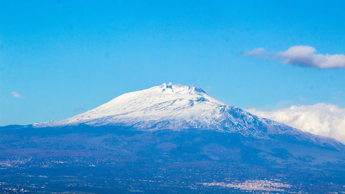 Scenic view of snowcapped mountains against blue sky