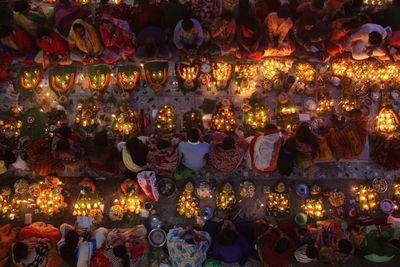 Directly above shot of people with illuminated diyas during religious fasting at night