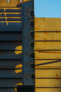 Close-up of yellow metal structure against sky