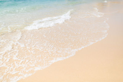 Waves rushing towards shore on a sandy beach in portugal