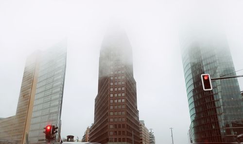 Low angle view of skyscrapers in fog