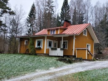 House amidst trees and buildings during winter