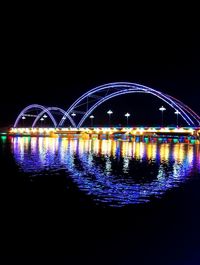 Illuminated light trails in city against clear sky at night