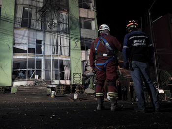 Rear view of people against built structure