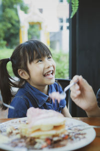 Portrait of boy holding ice cream on table