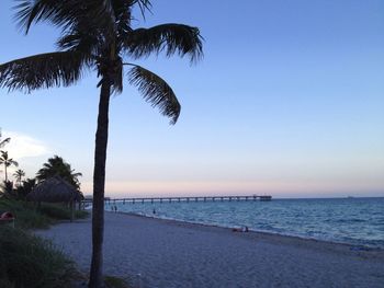 Scenic view of calm beach against clear blue sky