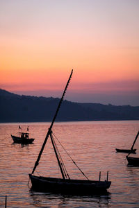 Silhouette boat in sea against sky during sunset