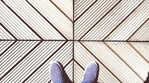 Low section of man standing on tiled floor