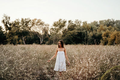 Full length of woman standing on field against sky