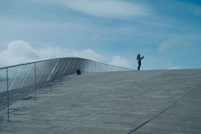 Side view of man standing against sky