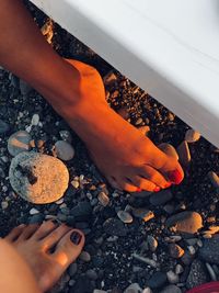 High angle view of person hand on stone