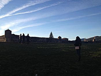 Woman walking on landscape against clear sky