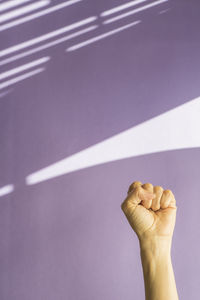 Cropped hand of woman against wall at home