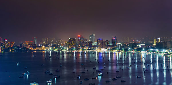 Illuminated buildings in city against sky at night