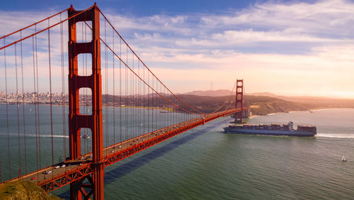 Suspension bridge over bay against sky