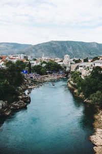 High angle view of river amidst houses against sky