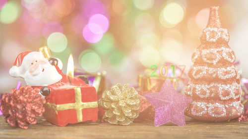 Close-up of lit candle with christmas decorations on table