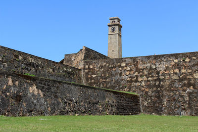 Low angle view of fort against clear blue sky