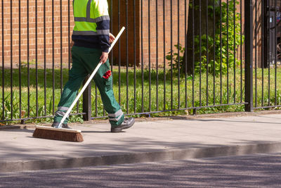 Street cleaner walking with his broom along clean streets in hackney, london 