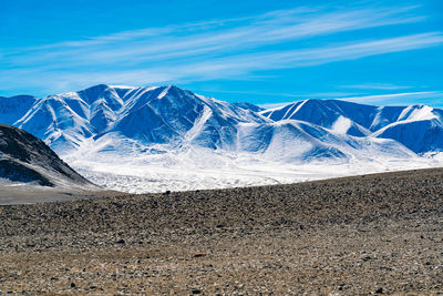 Scenic view of snowcapped mountains against blue sky