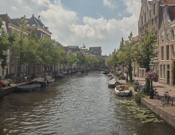 Canal amidst buildings against sky