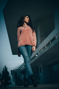 Portrait of woman standing against building in city