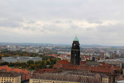 Buildings in city against cloudy sky