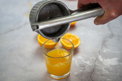 Close-up of hand pouring drink in glass