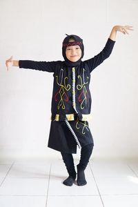 Low angle view of young woman standing against wall