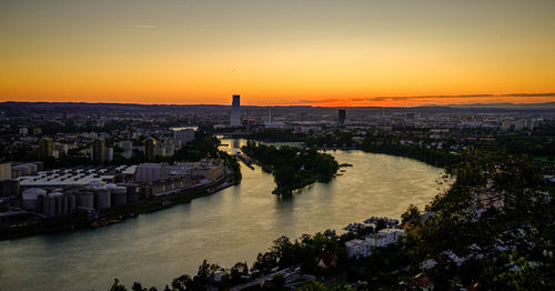 High angle view of river and buildings against sky during sunset