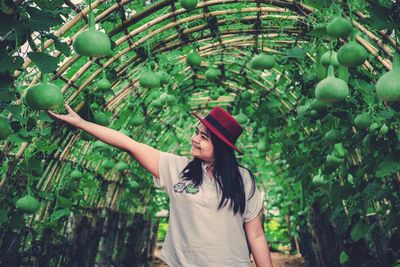 Full length of woman standing by plants