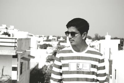 Man in sunglasses standing against buildings