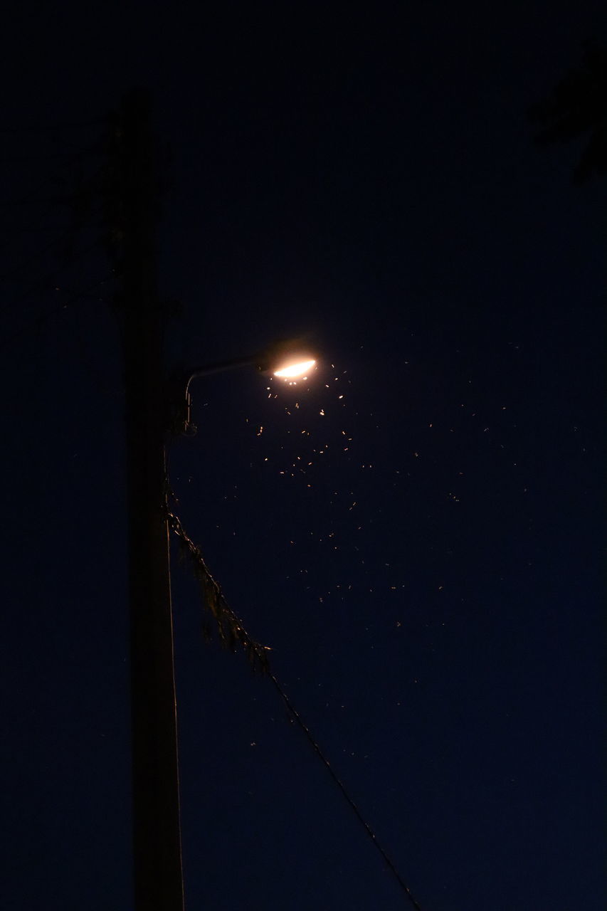 LOW ANGLE VIEW OF ILLUMINATED LIGHTS AT NIGHT