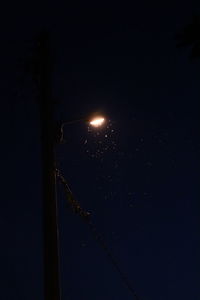 Low angle view of illuminated street light against sky at night