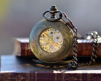 Close-up of pocket watch with book