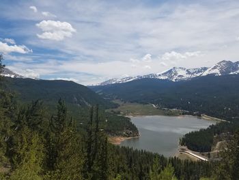 Scenic view of mountains against river against sky